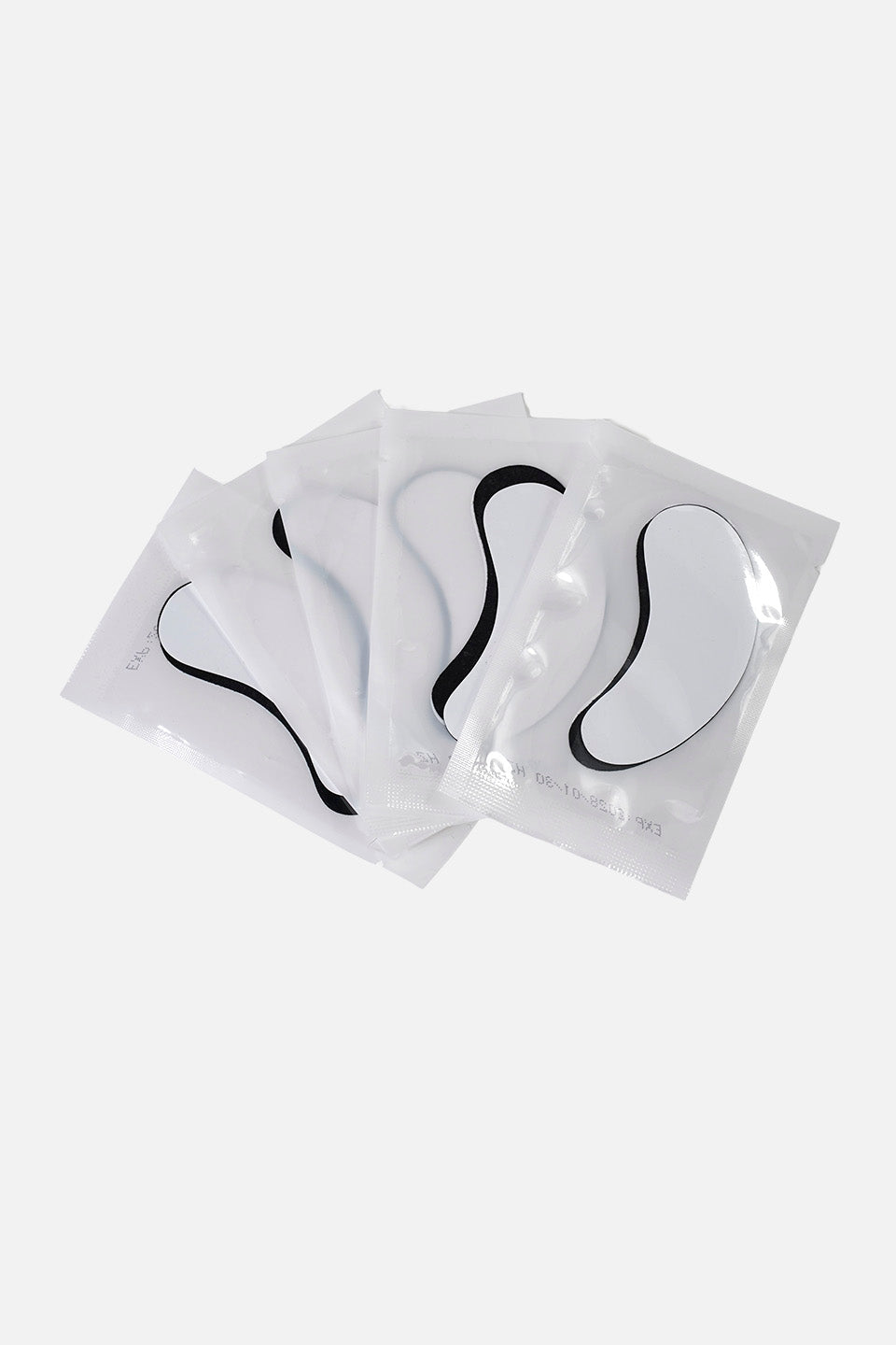 Confezioni singole sigillate di patch occhi in hydrogel di colore nero. Le bustine sono bianche e disposte a ventaglio su fondo neutro.