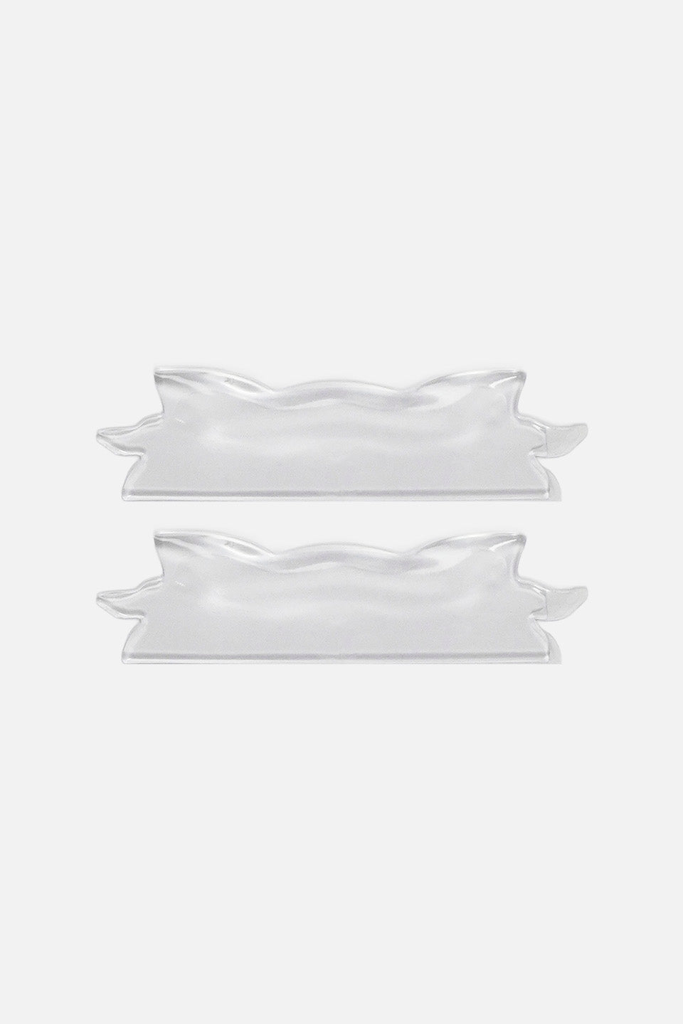 Due bigodini piatti ondulati in silicone trasparente per laminazione ciglia coreana, posizionati in parallelo in senso orizzontale per mostrare la particolare forma sagomata del bordo.