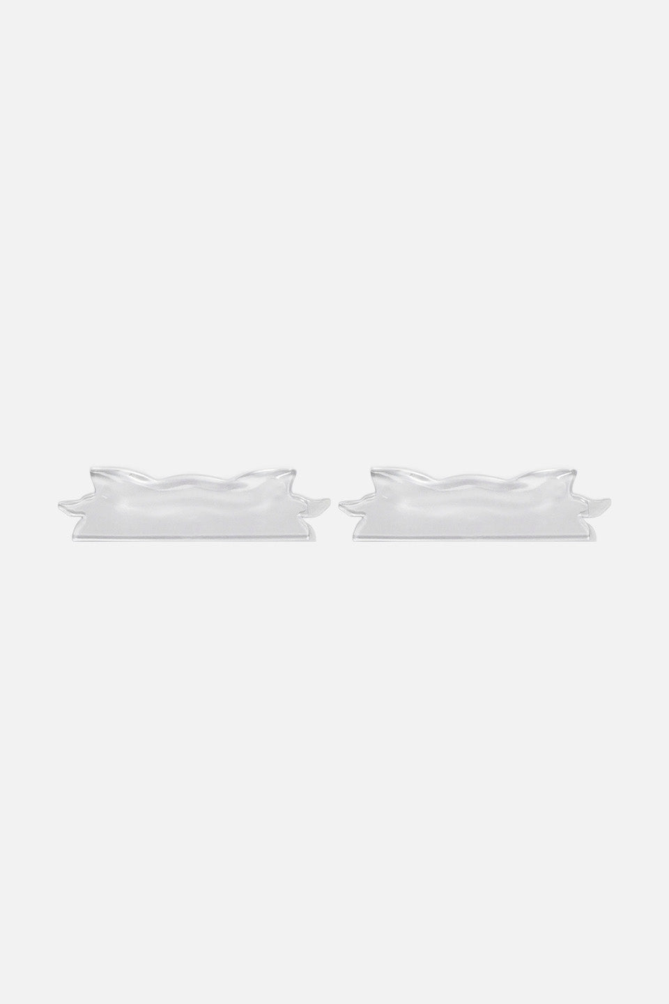 Coppia di bigodini piatti con profilo ondulato in silicone flessibile trasparente per laminazione ciglia, disposti l'uno di fianco all'altro in linea orizzontale su sfondo bianco.