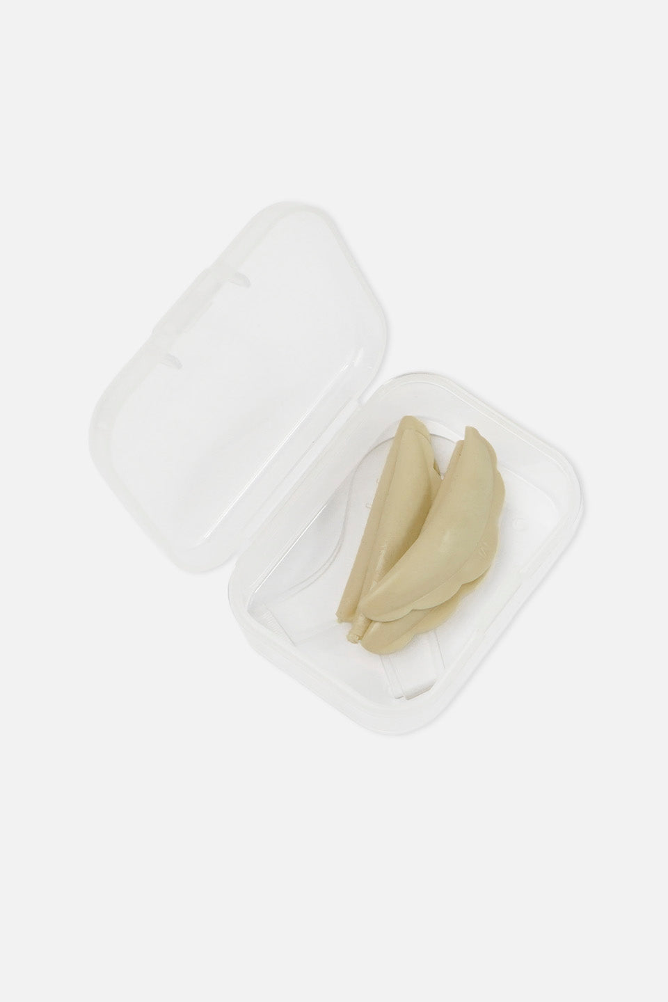 Kit di bigodini curvi beige in silicone per laminazione ciglia coreana, riposti all'interno della loro custodia protettiva in plastica trasparente aperta, su sfondo bianco.