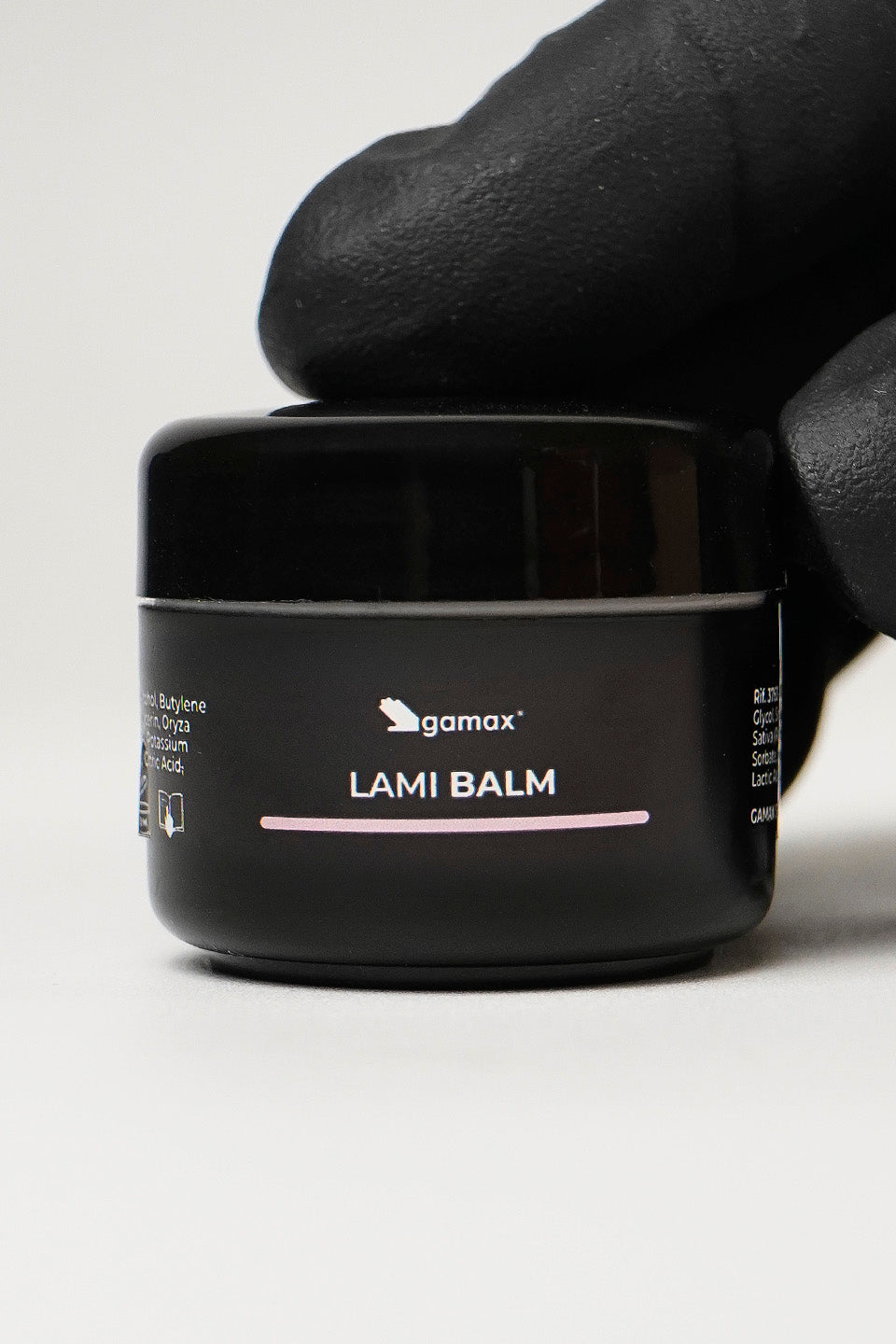 primo piano di una mano che tiene il flacone chiuso del lami balm colla non colla