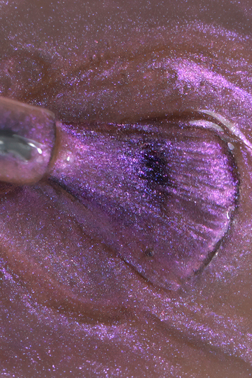 Primo piano del flacone nero opaco Gamax "SEMIPERMANENTE Soak off System". L'applicatore sollevato mostra una goccia di smalto viola-rosa con riflessi magnetici argentati e brillanti. Il collo del flacone rivela la densità del prodotto e la sua finitura luminosa e metallizzata.