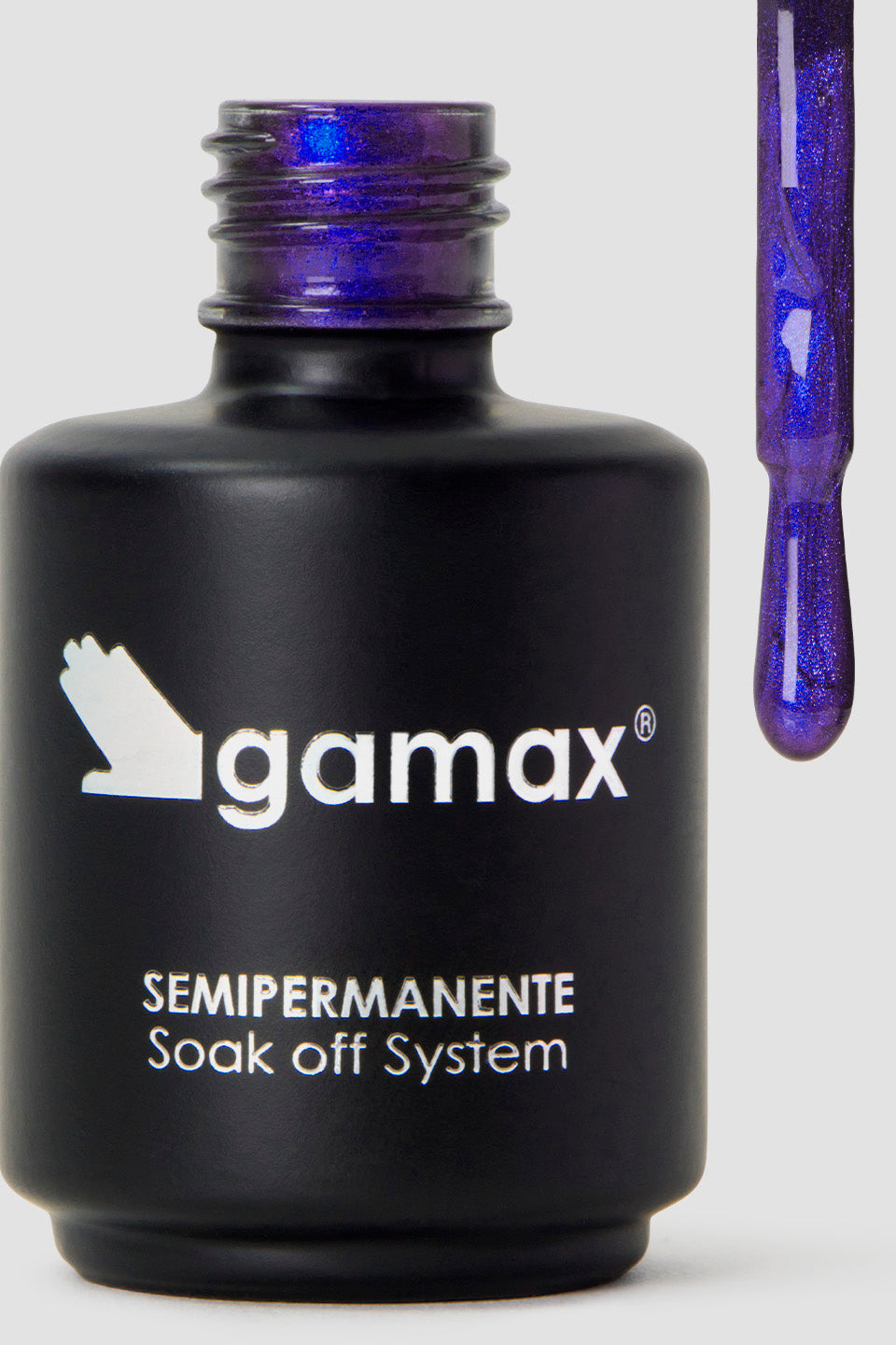 Macro della texture di uno smalto semipermanente "Cat Eye" nei toni dell'indaco. Un pennellino piatto è immerso nel colore, rivelando una formula ricca di micro-pigmenti magnetici e glitter luminosi che creano sfumature multidimensionali e brillanti.