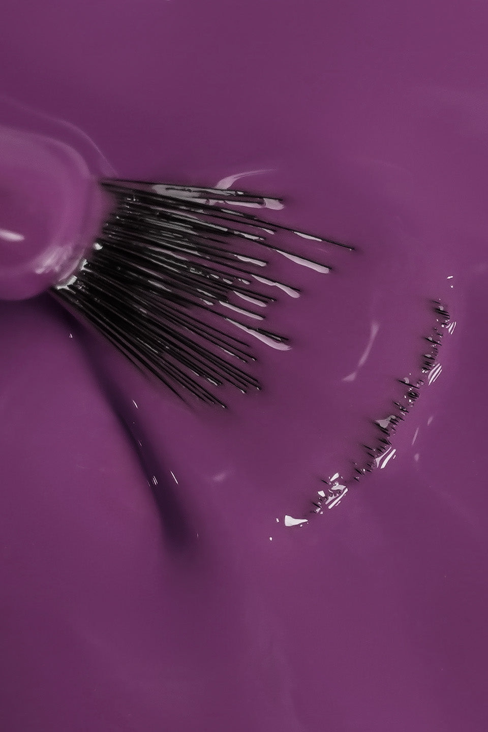 Primo piano della texture fluida e ultra-lucida dello smalto semipermanente viola steso con pennello professionale