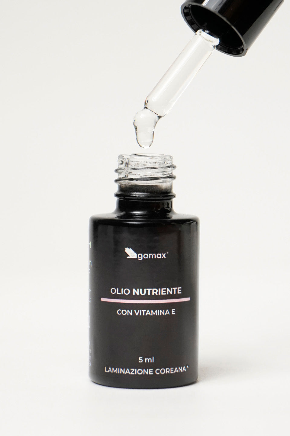 Flacone olio nutriente con tappo contagocce aperto, goccia di olio che fuoriesce dal contagocce
