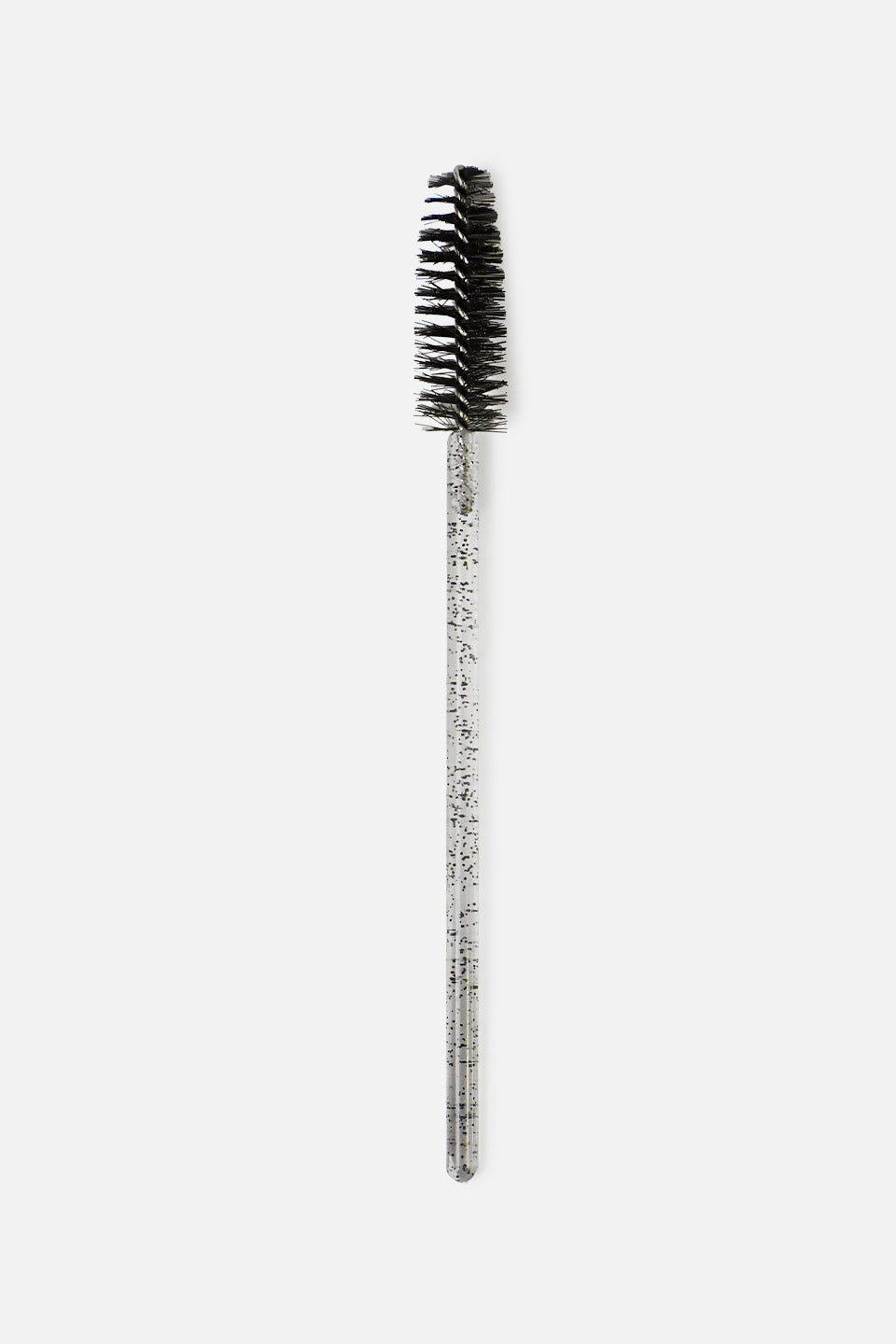 Vista intera e verticale di un singolo scovolino monouso per ciglia. Presenta un lungo manico dritto in plastica trasparente con brillantini e una testina con setole nere, isolato su sfondo bianco