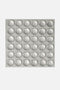 Foglio quadrato contenente 36 bolle adesive in silicone paracolpi sferici e trasparenti per tastiera pc, (disposti in una griglia 6x6) su sfondo grigio chiaro uniforme.