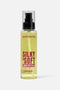 Flacone spray trasparente di cristalli liquidi per capelli "Silky & Soft" del marchio Extremo con olio di argan, contenente un fluido dorato. sfondo bianco.