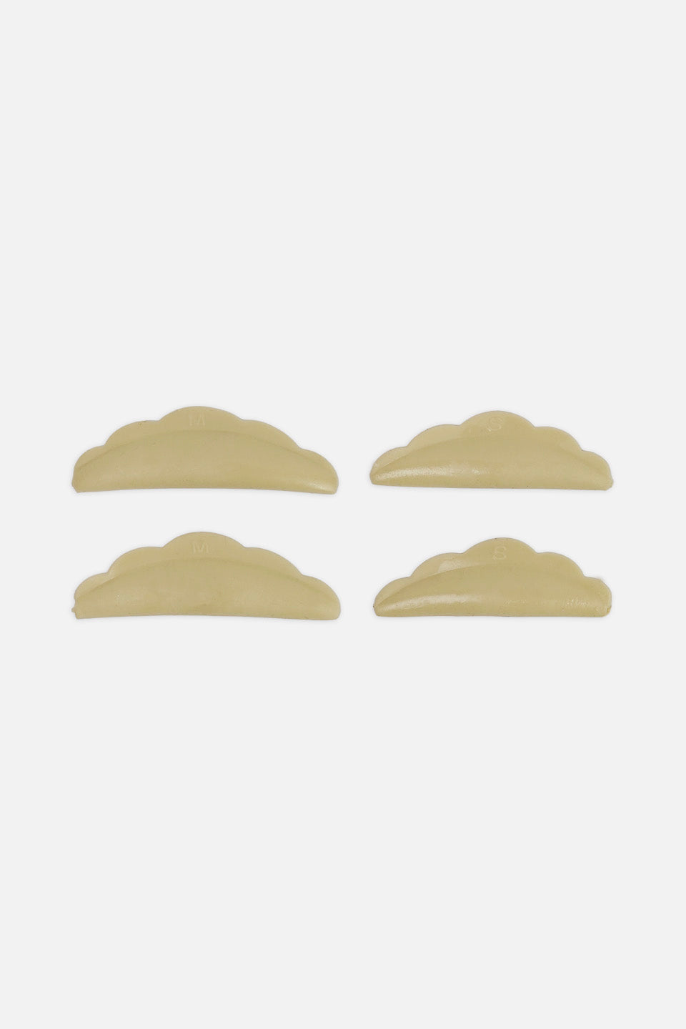 Quattro bigodini curvi beige in silicone per laminazione ciglia, disposti orizzontalmente su due file per mostrare il design anatomico e le scanalature delle misure S e M.