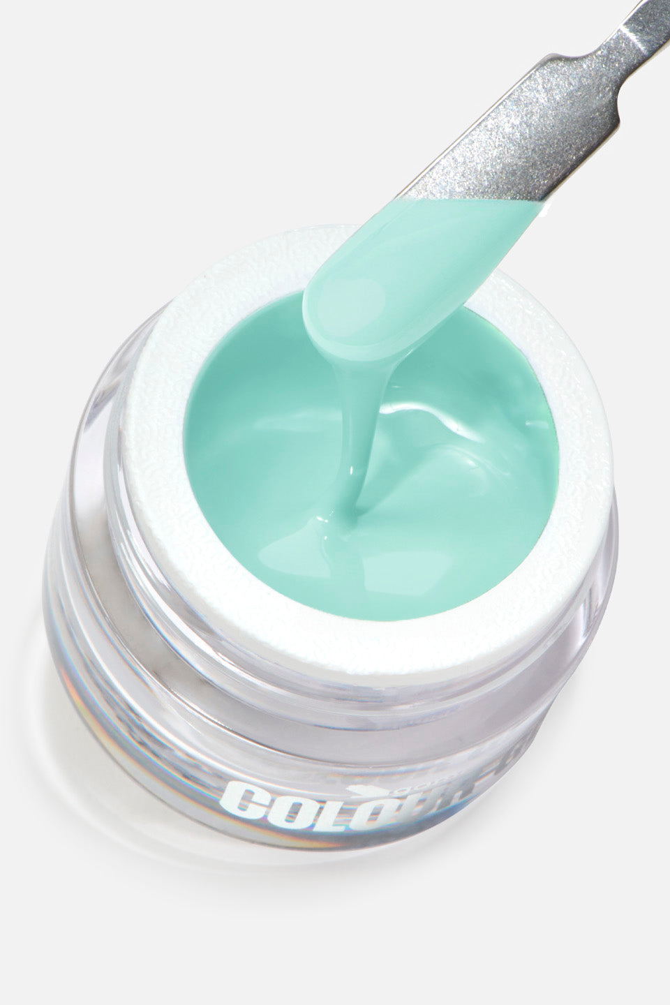 Primo piano di un barattolo di gel colorato dove una spatola metallica solleva una goccia densa di prodotto. Il gel è di una tonalità azzurro pastello coprente e mostra una consistenza fluida ma viscosa mentre cola nuovamente nel contenitore.