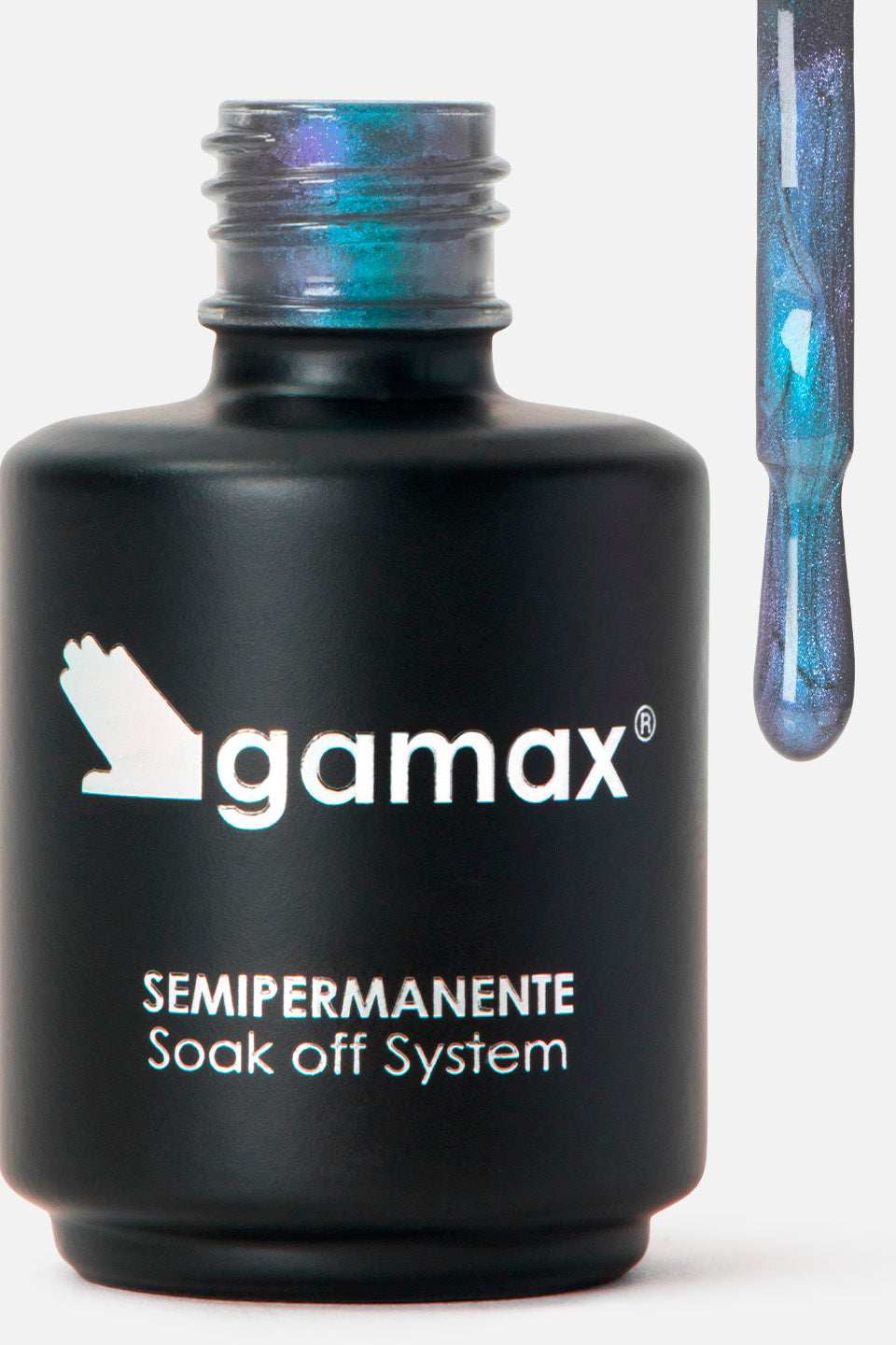 Primo piano di un flacone di smalto nero opaco del marchio Gamax con la scritta "SEMIPERMANENTE Soak off System". Accanto al flacone, l'applicatore sollevato mostra una goccia di smalto densa e glitterata con riflessi cangianti tra il blu, il verde smeraldo e il viola scuro