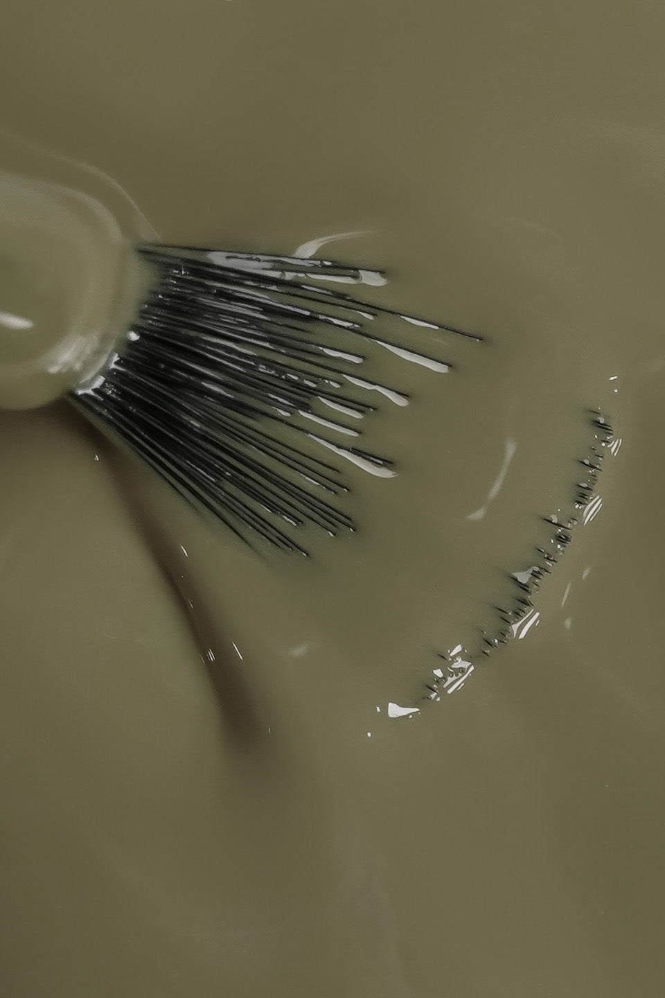 primo piano pennello che mostra texture dello smalto semipermanente verde chiaro 