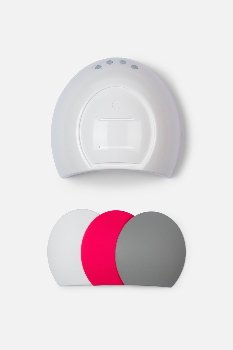 Vista dall'alto di una lampada professionale per unghie di colore bianco, dalla forma a cupola con piccoli pulsanti di controllo sulla parte superiore. Sotto la lampada sono disposti tre copri lampada intercambiabili di forma semicircolare nei colori bianco, fucsia e grigio, sovrapposti leggermente tra loro