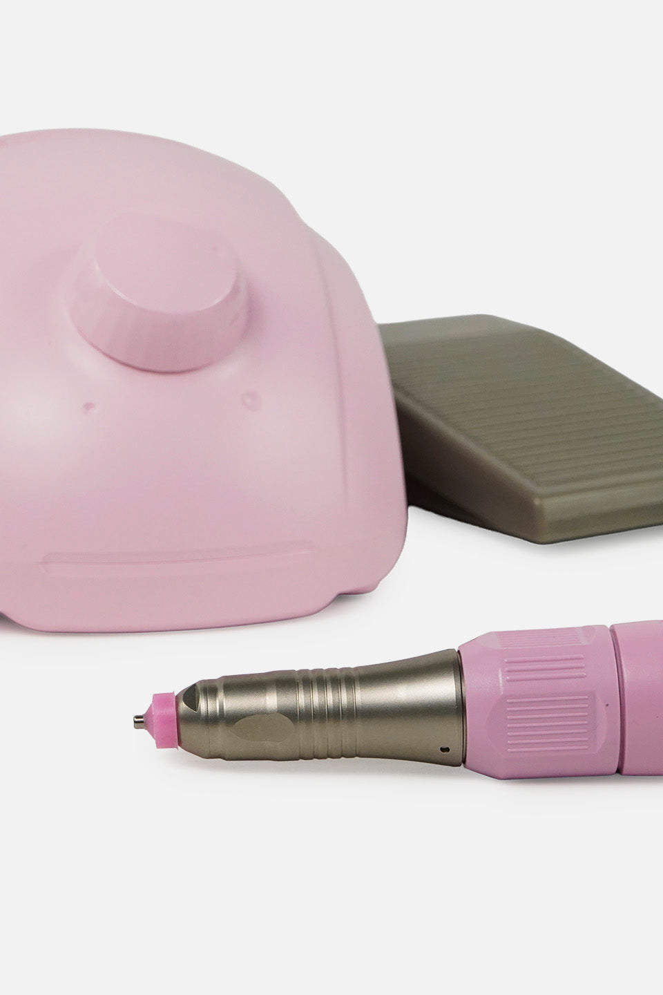 Dettaglio ravvicinato del micromotore unghie rosa con pedale e manipolo, focus su manopola e punta.