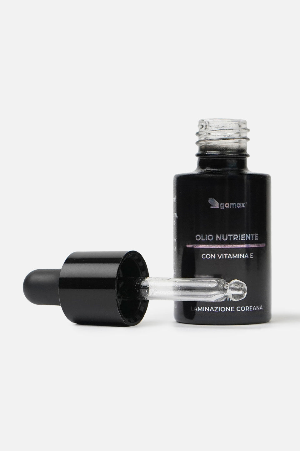 flacone olio nutriente con tappo contagocce aperto poggiato sul lato sinistro