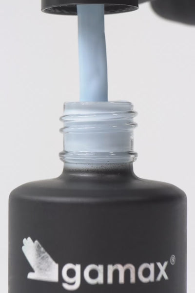 Breve video dimostrativo dell'applicazione di uno smalto semipermanente color azzurro chiaro. Sequenza di scene: il pennellino viene estratto dal flacone Gamax lasciando gocciolare il prodotto, viene immerso nella boccetta mostrando la texture fluida e infine stende lo smalto con precisione sulla superficie di un'unghia, lasciando una finitura lucida e uniforme.