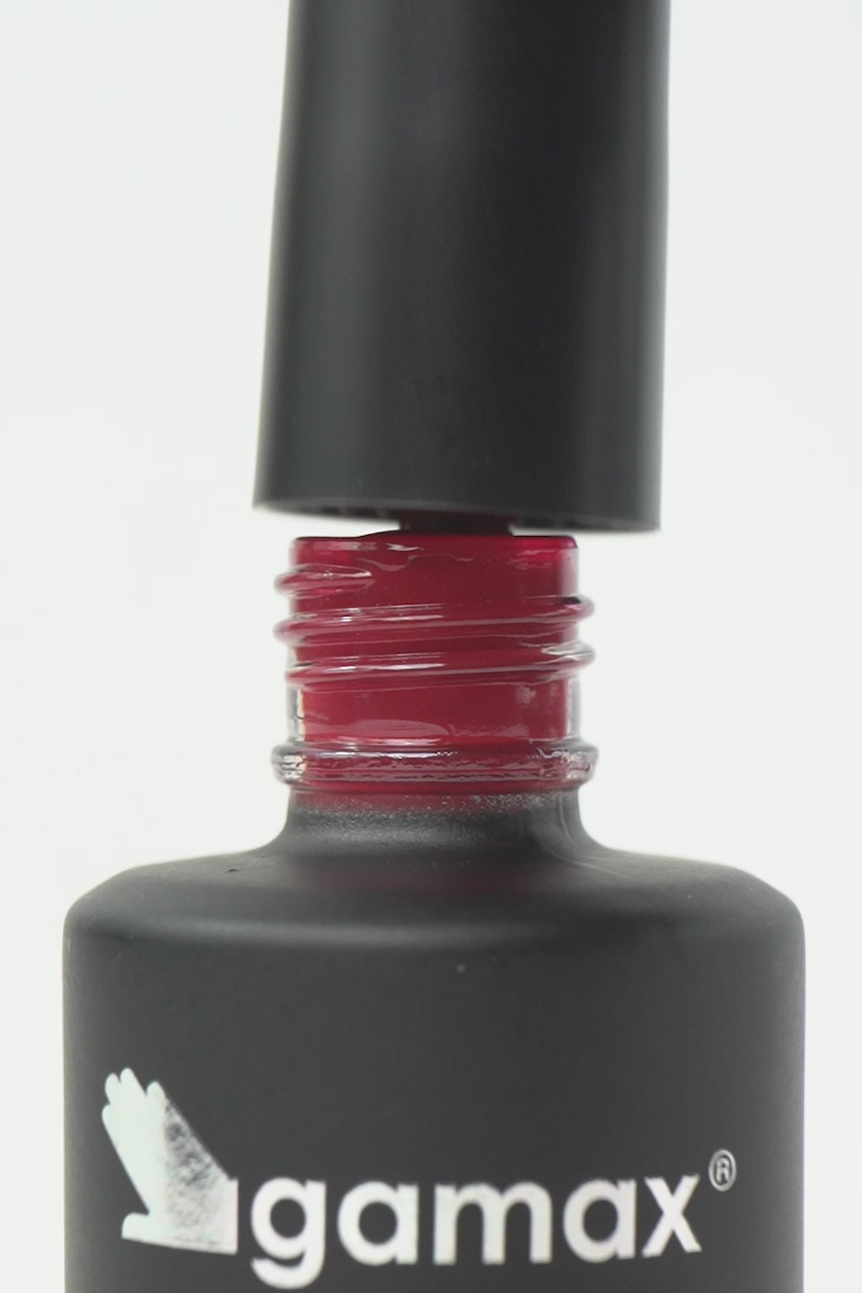 Video macro dello smalto semipermanente Desiderio color rosso rubino. Mostra il pennellino che preleva una goccia densa e lucida dal flacone, l'applicazione fluida su unghia naturale e il finish finale ultra brillante, coprente e liscio effetto vetro