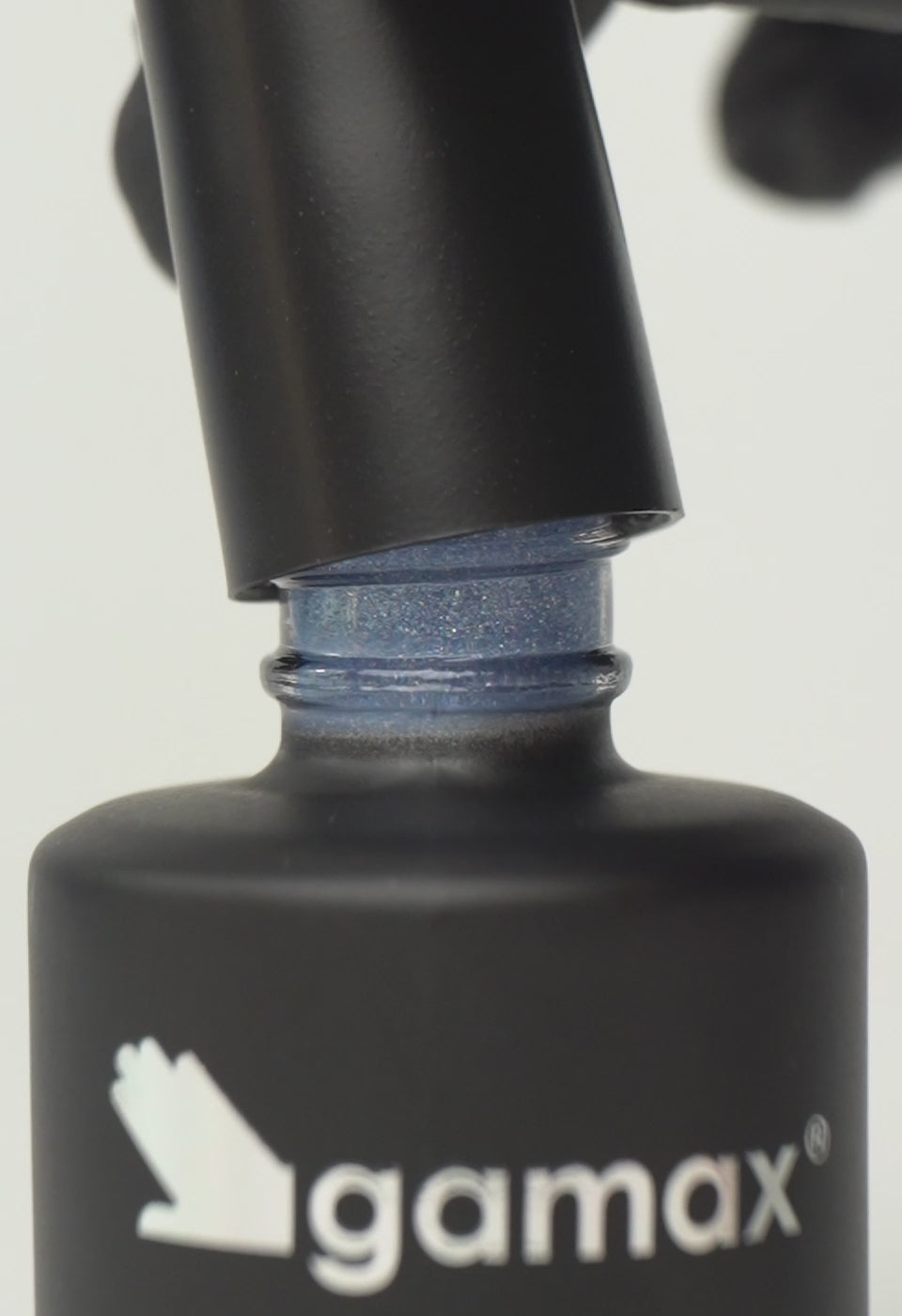 Si succedono diversi frame che mostrano il flacone nero contenente lo smalto semipermanente Grey Moon glitterato di Gamax, la texture dello smalto e infine un'unghia su cui viene applicato il prodotto
