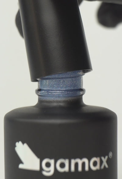 Si succedono diversi frame che mostrano il flacone nero contenente lo smalto semipermanente Grey Moon glitterato di Gamax, la texture dello smalto e infine un'unghia su cui viene applicato il prodotto