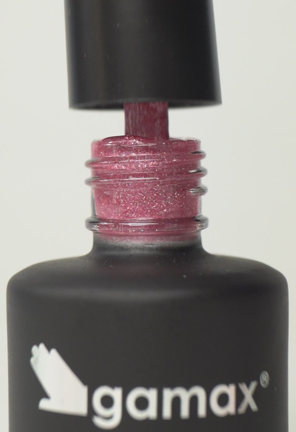 Si succedono diversi frame che mostrano il flacone nero contenente lo smalto semipermanente rosa sparkly pink glitterato di Gamax, la texture dello smalto e infine un'unghia su cui viene applicato il prodotto