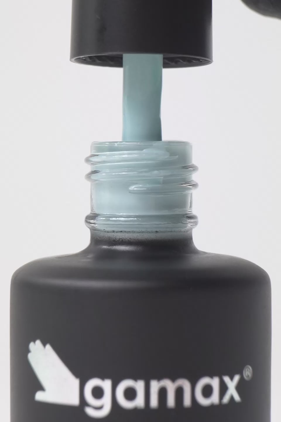 Breve video dimostrativo dell'applicazione di uno smalto semipermanente color turchese chiaro. Sequenza di scene: il pennellino viene estratto dal flacone Gamax lasciando gocciolare il prodotto, viene immerso nella boccetta mostrando la texture fluida e infine stende lo smalto con precisione sulla superficie di un'unghia, lasciando una finitura lucida e uniforme.
