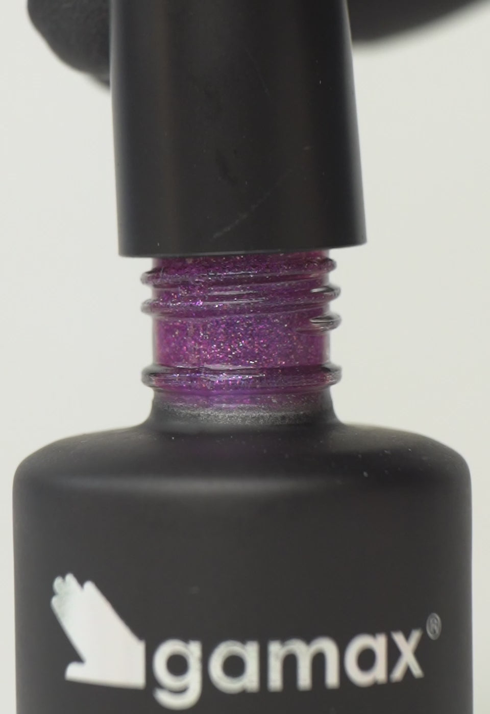 Si succedono diversi frame che mostrano il flacone nero contenente lo smalto semipermanente purple pop glitterato di Gamax, la texture dello smalto e infine un'unghia su cui viene applicato il prodotto