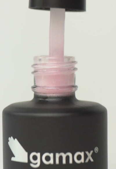 Si succedono diversi frame che mostrano il flacone nero contenente il top coat rosa cristallo di Gamax, la texture dello smalto e infine un'unghia su cui viene applicato il prodotto
