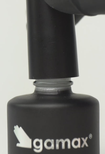 Si succedono diversi frame che mostrano il flacone nero contenente il top coat bianco latte intenso di Gamax, la texture dello smalto e infine un'unghia su cui viene applicato il prodotto