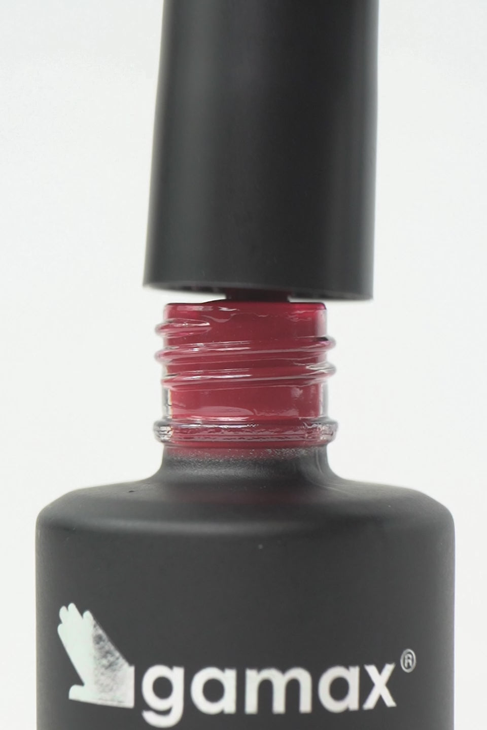 Video macro dello smalto semipermanente Sussurro color rosa scuro. Mostra il pennellino che preleva una goccia densa e lucida dal flacone, l'applicazione fluida su unghia naturale e il finish finale ultra brillante, coprente e liscio effetto vetro