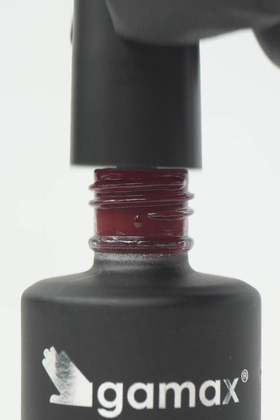 Video macro dello smalto semipermanente Eclisse color bordeaux scuro. Mostra il pennellino che preleva una goccia densa e lucida dal flacone, l'applicazione fluida su unghia naturale e il finish finale ultra brillante, coprente e liscio effetto vetro