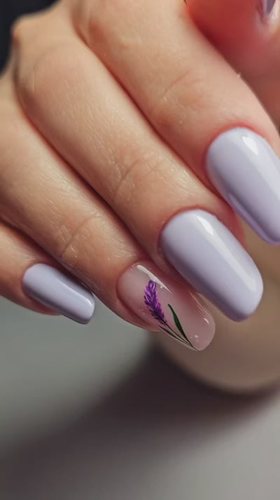 Tutorial nail art per mostrare l'effetto del sigillate lucido sealant di Gamax. L'onicotecnica realizza delle unghie lilla con una nail art raffigurante un fiore di lavanda