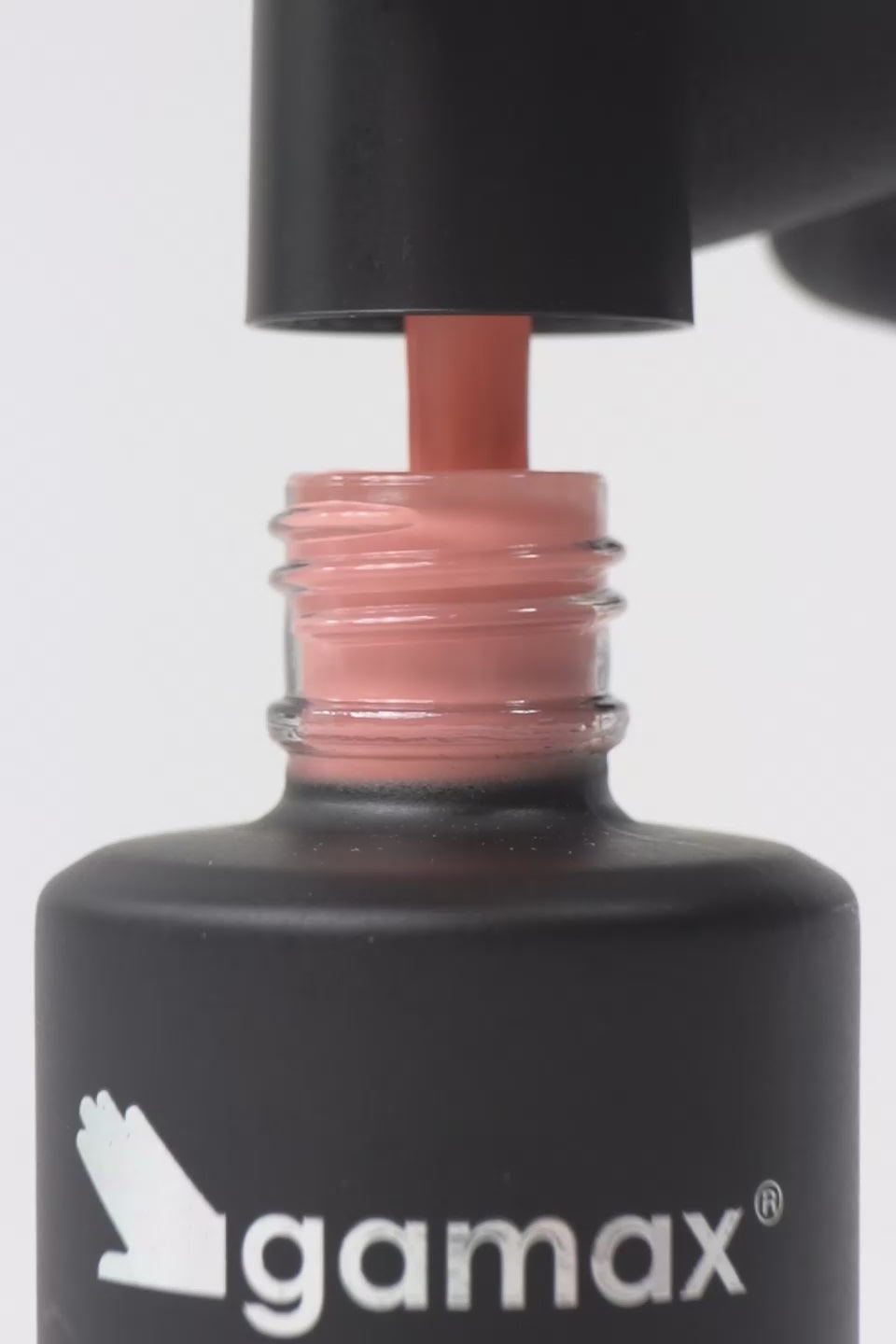 Breve video dimostrativo dell'applicazione di uno smalto semipermanente color arancione chiaro pesca. Sequenza di scene: il pennellino viene estratto dal flacone Gamax lasciando gocciolare il prodotto, viene immerso nella boccetta mostrando la texture fluida e infine stende lo smalto con precisione sulla superficie di un'unghia, lasciando una finitura lucida e uniforme.