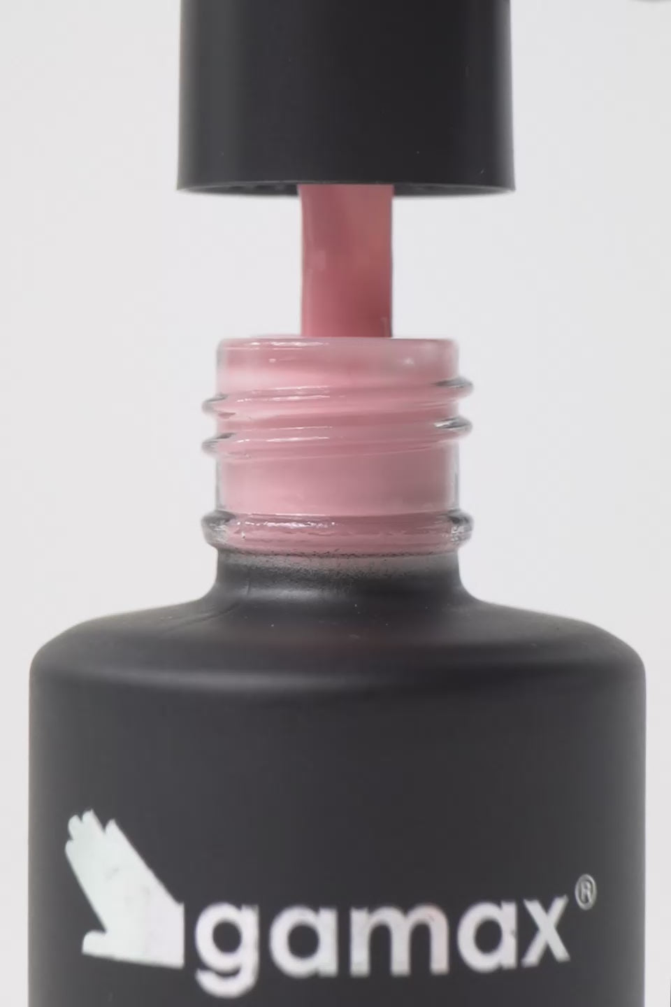Breve video dimostrativo dell'applicazione di uno smalto semipermanente color rosa chiaro. Sequenza di scene: il pennellino viene estratto dal flacone Gamax lasciando gocciolare il prodotto, viene immerso nella boccetta mostrando la texture fluida e infine stende lo smalto con precisione sulla superficie di un'unghia, lasciando una finitura lucida e uniforme.