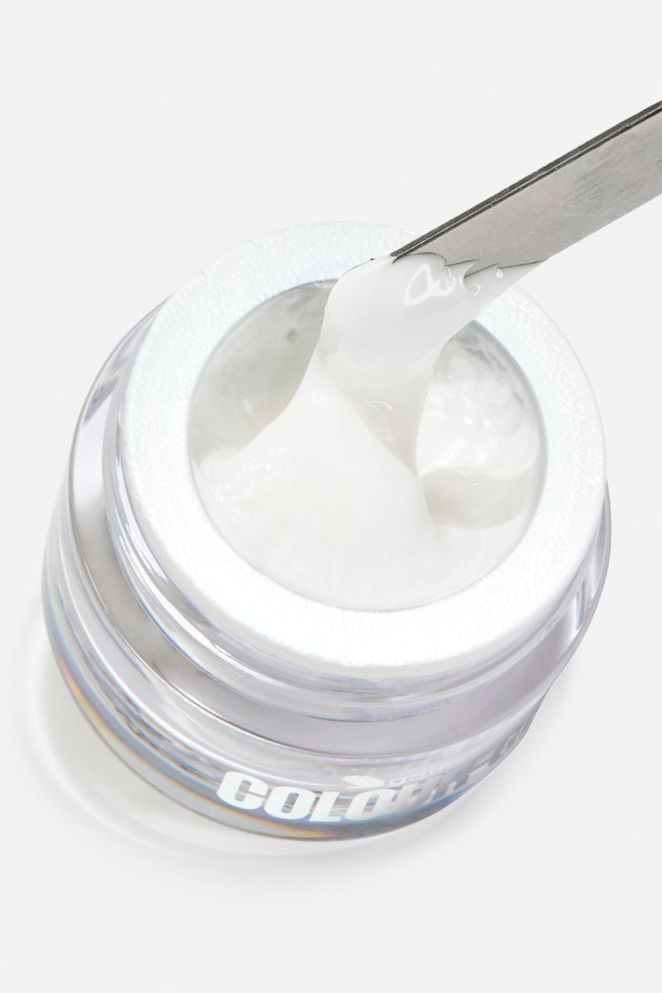 Primo piano dall'alto di un barattolino trasparente contenente spider gel di colore bianco intenso. Una spatola metallica solleva una porzione densa e cremosa di prodotto, mostrandone la texture ricca e corposa all'interno del vasetto su sfondo bianco.