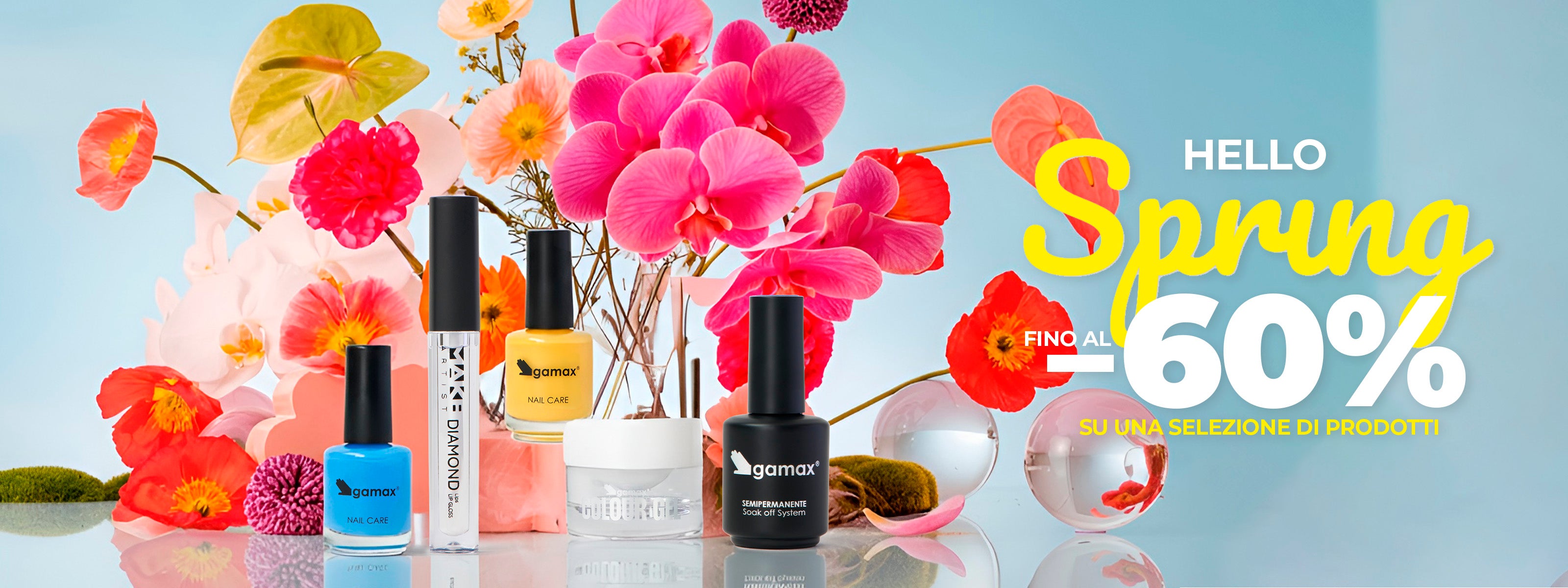 Banner orizzontale promozionale con focus sui prodotti Gamax e ambientazione floreale vivida. Il testo principale recita: "Hello Spring, fino al -60% su una selezione di prodotti". I prodotti includono smalti "Nail Care" in blu e giallo, un gel "Colour Gel" e un flacone nero di semipermanente.